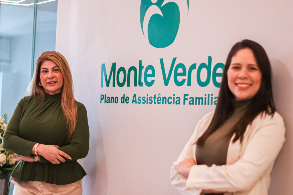 Duas mulheres diante da marca Monte Verde na unidade da empresa.