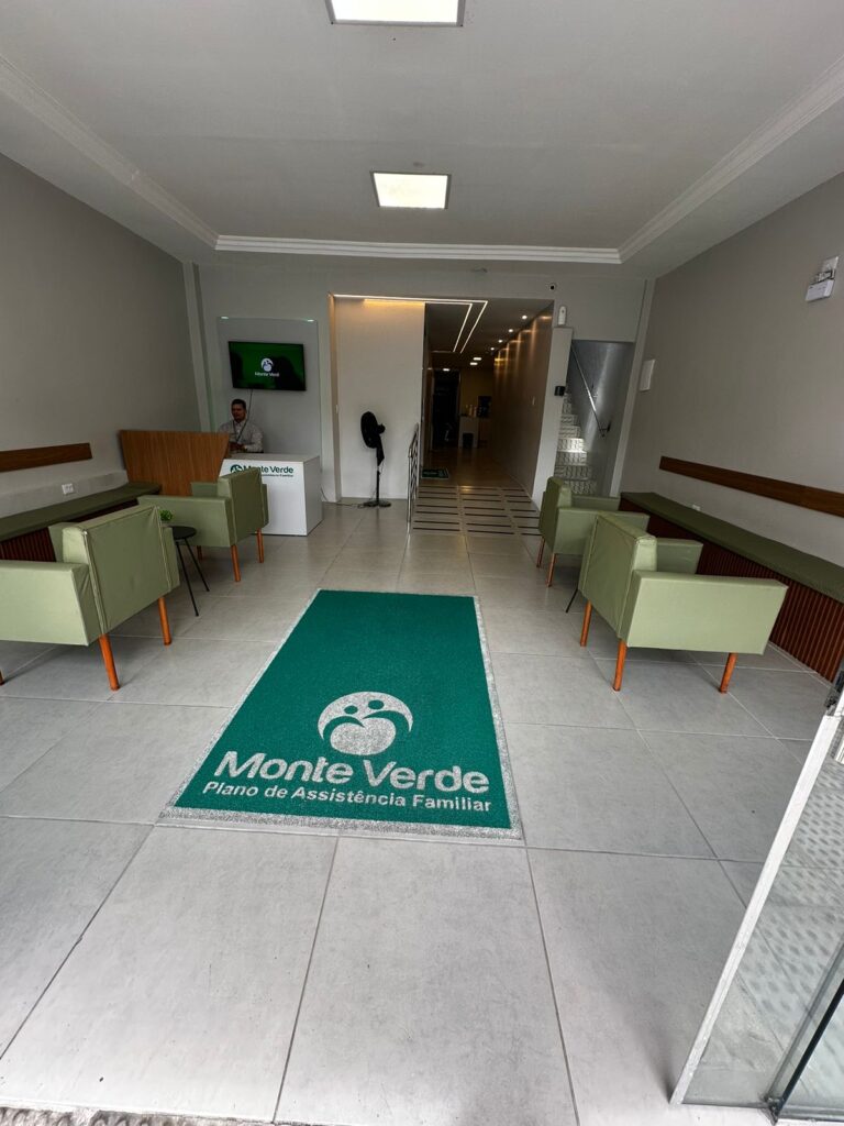 Recepção da Monte Verde, com poltronas e o tapete identificado com a marca.